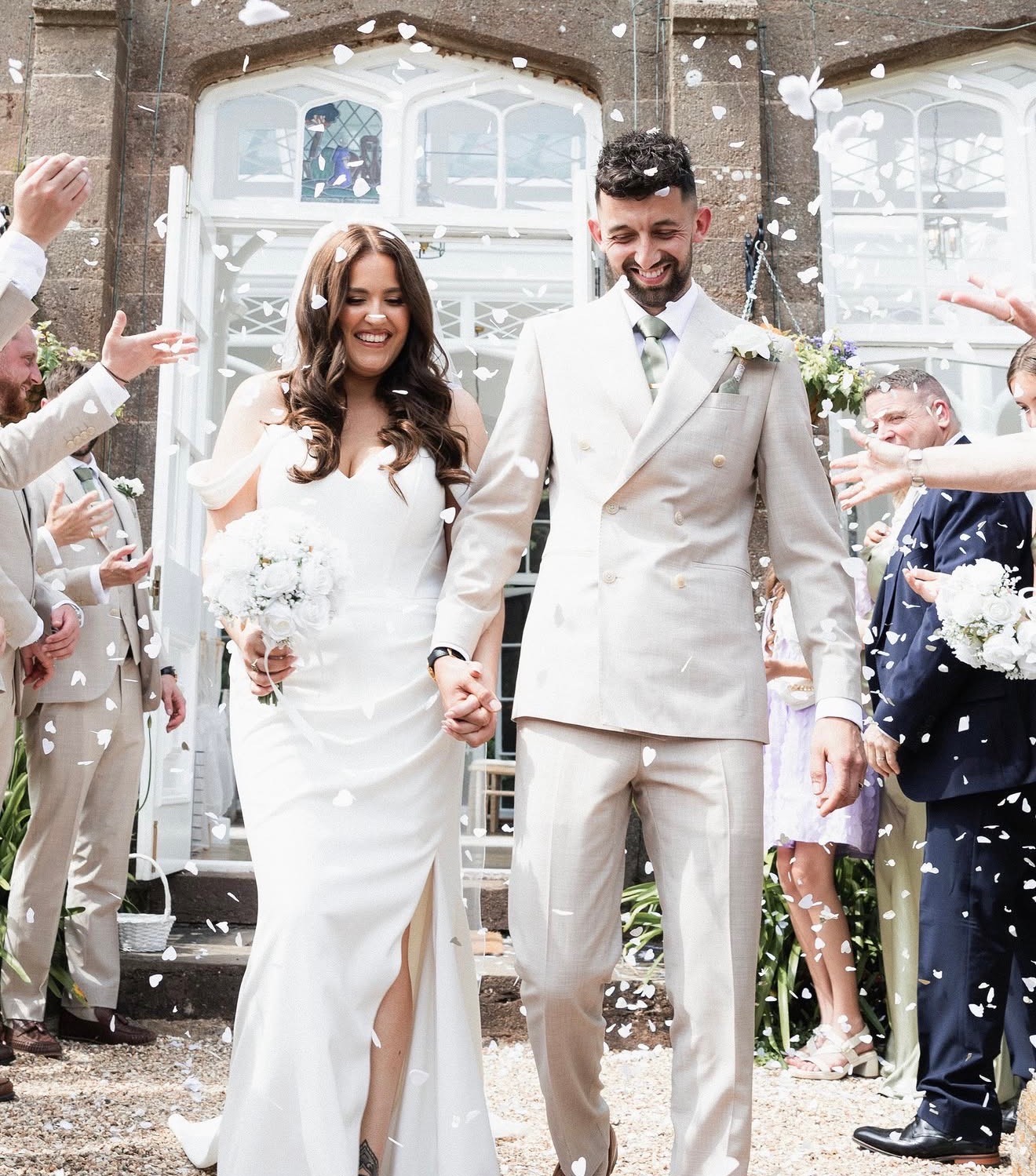 Newlyweds walking through confetti after their ceremony