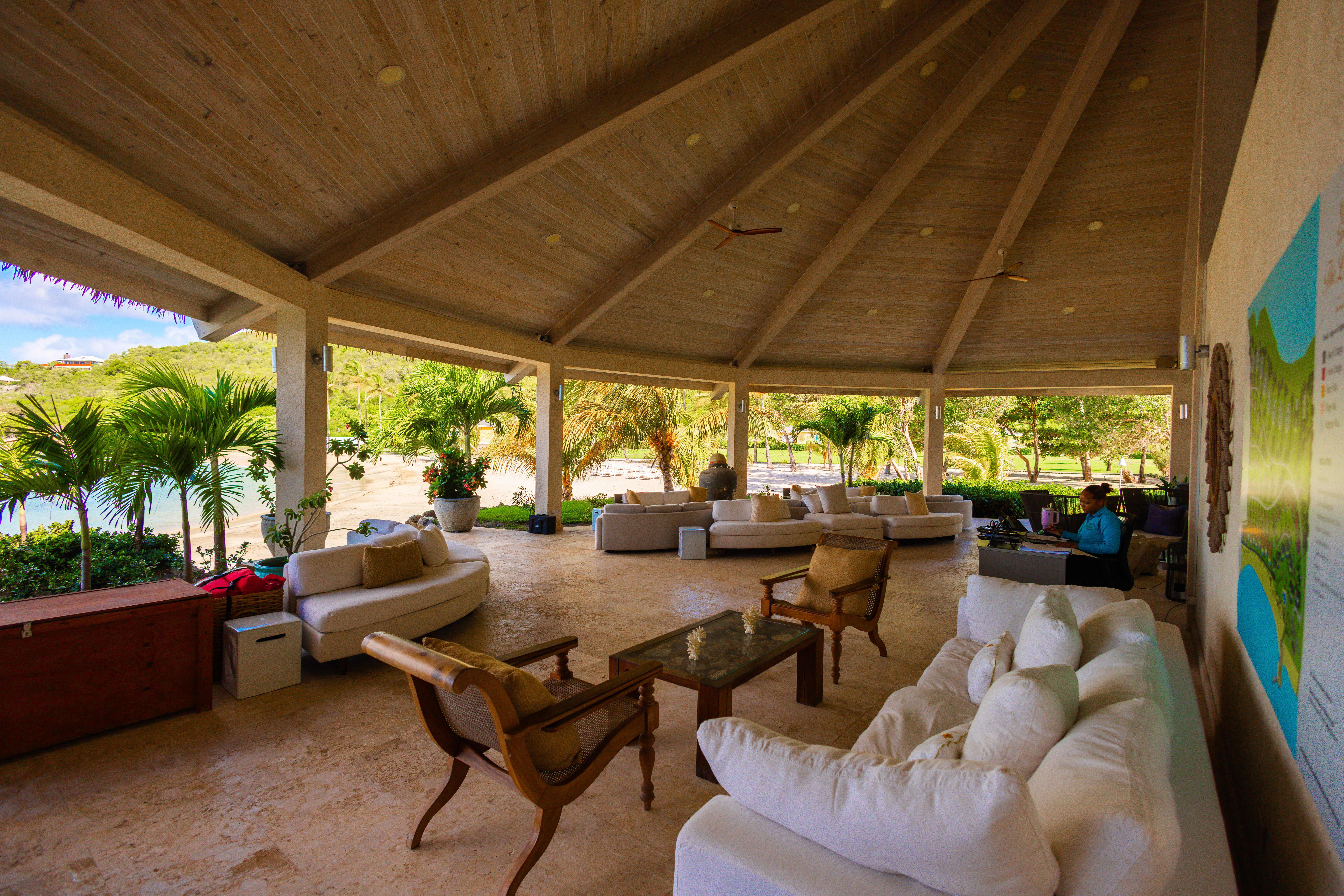 Open-air pavilion lounge with wooden ceiling, natural light, and relaxed seating