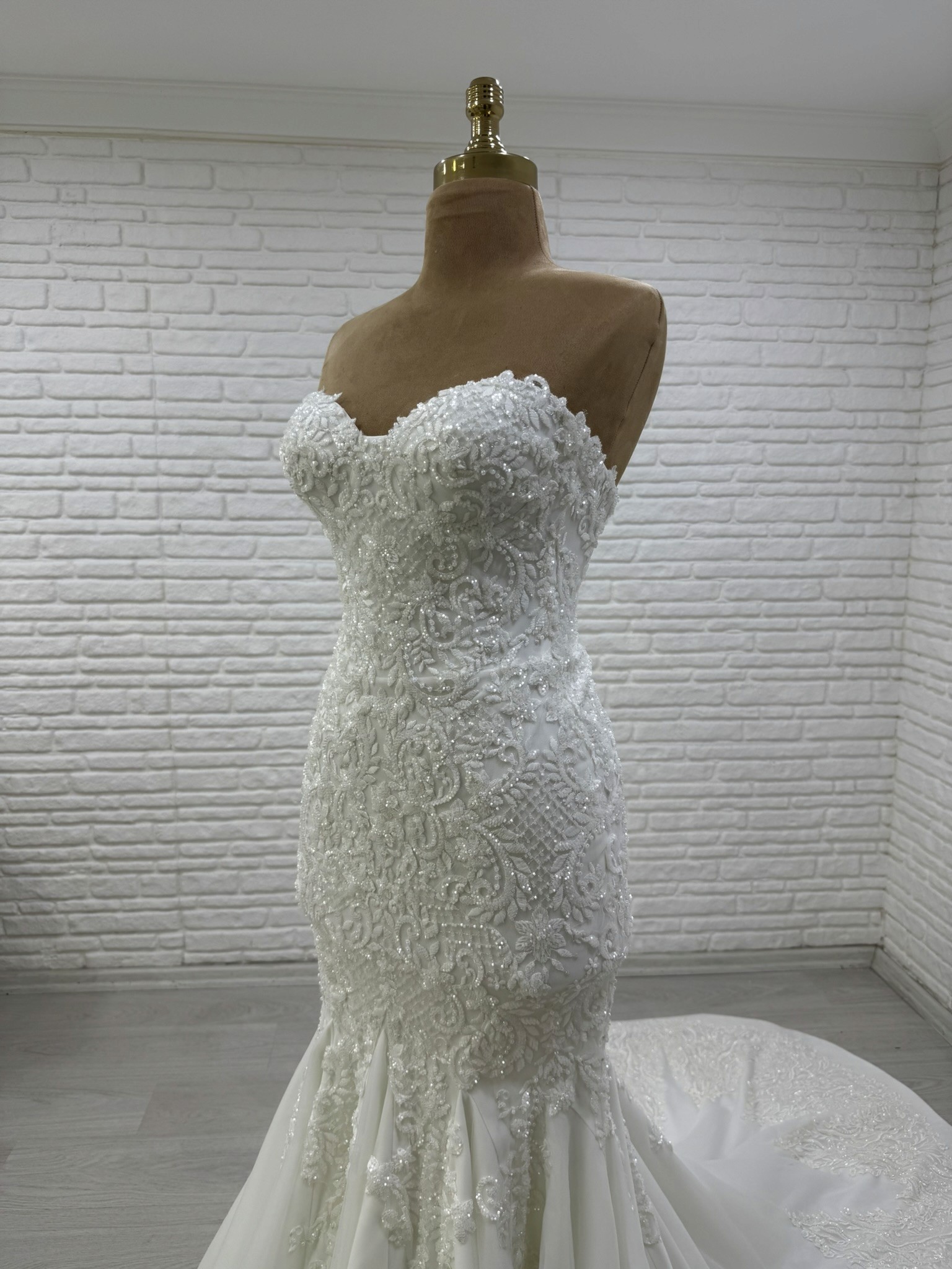 Final lace and corset inspection before a custom wedding dress is shipped