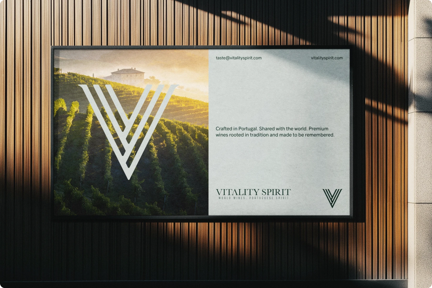 Framed Vitality Spirit wine billboard on a wood-paneled wall, showing a serene Portuguese forest landscape and bold white V logo.