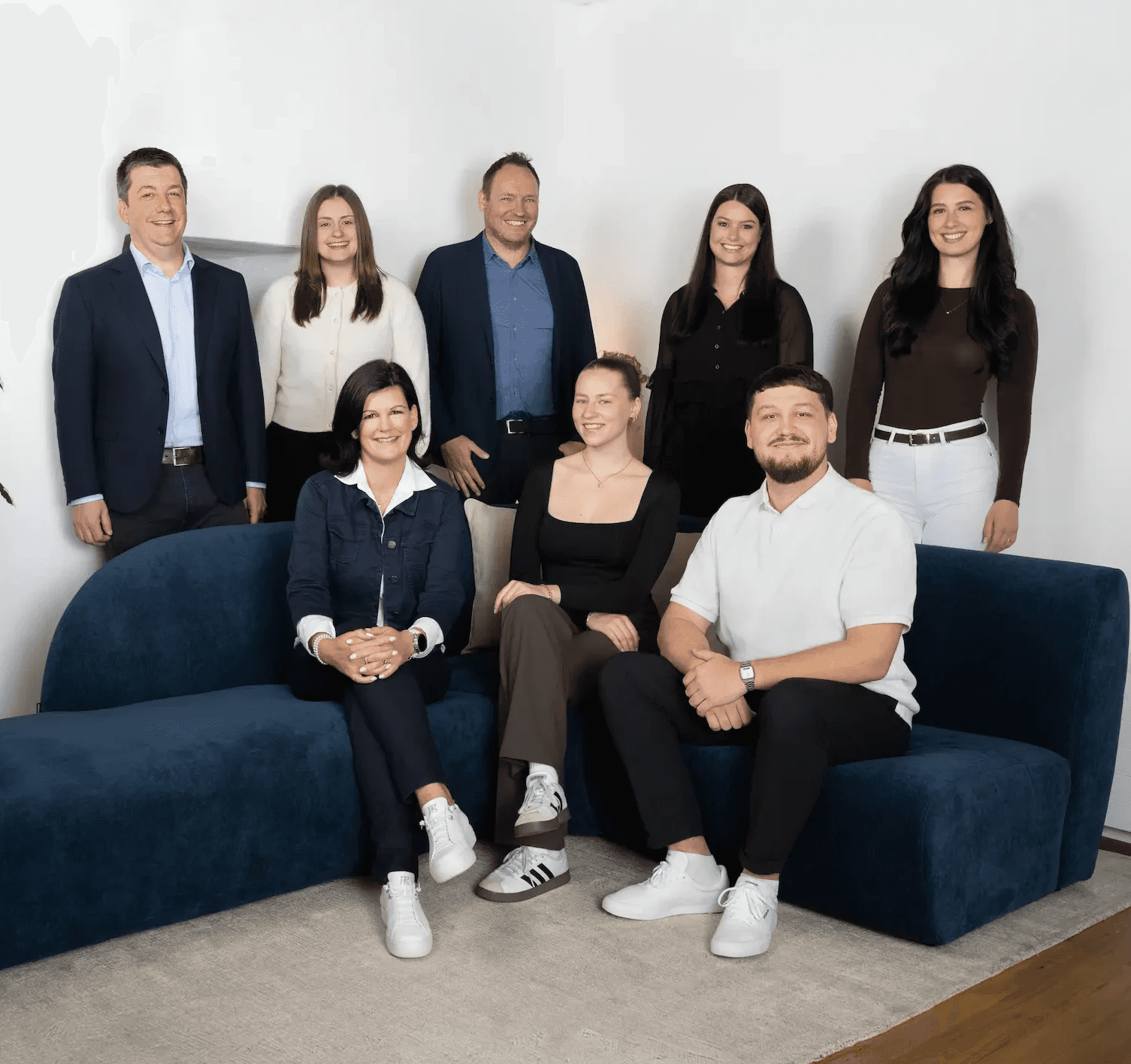 Gesamtes Kocher Immobilien Team sitzt auf einem Sofa in der ImmoLounge