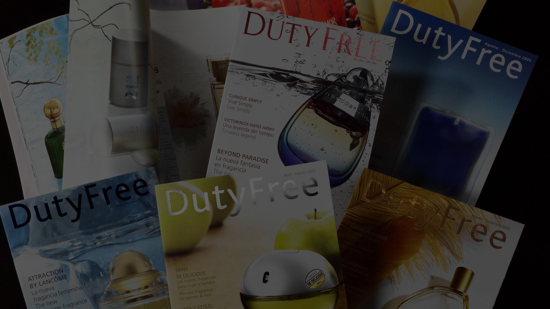A collection of Duty-Free magazines with vibrant cover designs, featuring perfume bottles, a candle, and nature-themed imagery, conveying luxury and travel.