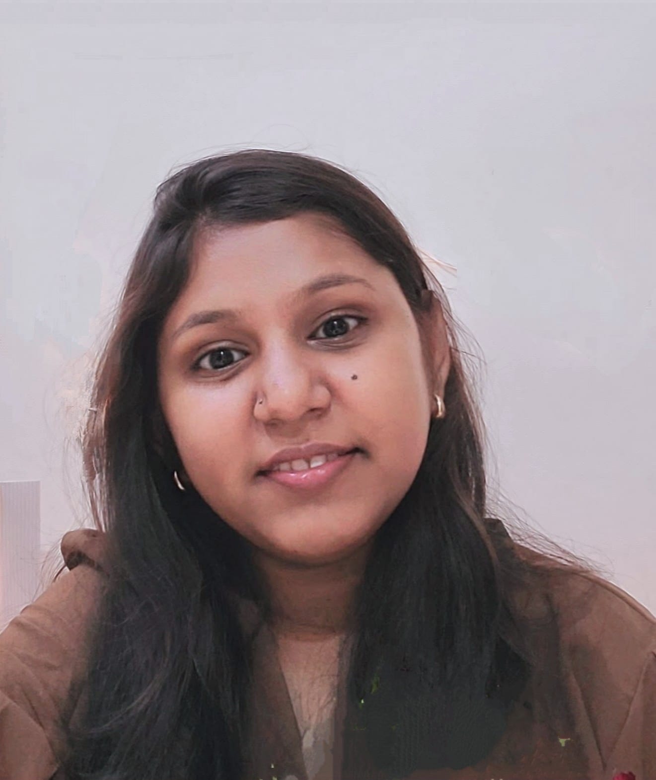 A businesswoman sitting at her desk, smiling and looking at the camera.