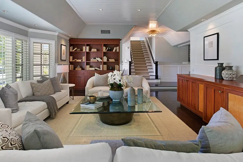 Port Streets Remodel' spacious living room with neutral tones, elegant furnishings, and wooden accents.