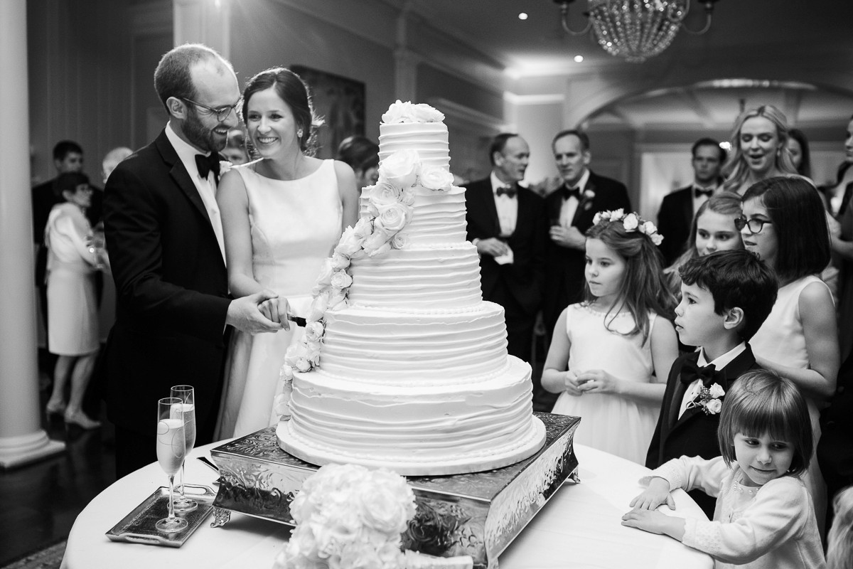 The bride and groom’s wedding cake cutting at The Belle Meade Country Club captured in black and white photography.