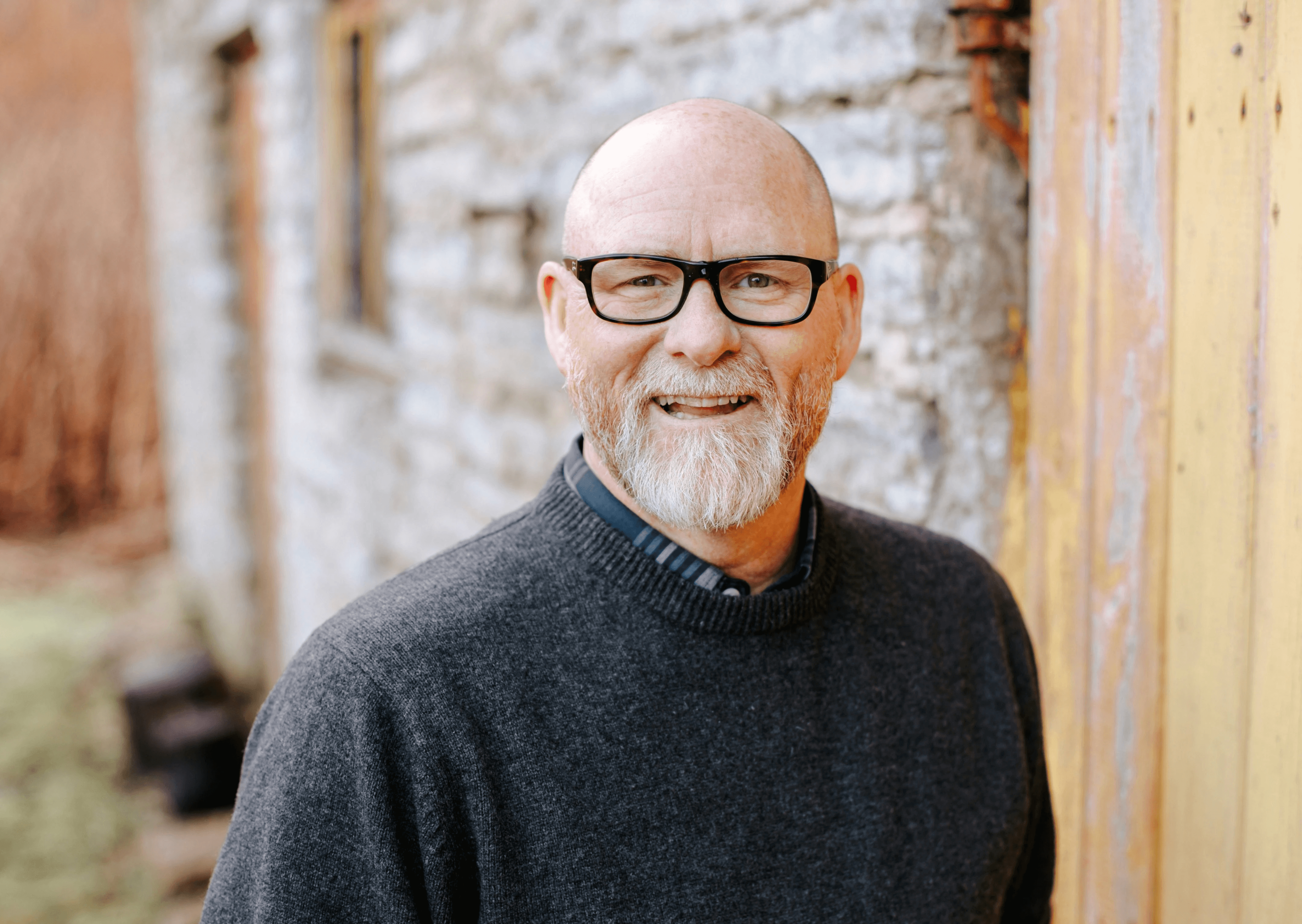 portrait of an older man wearing glasses and a dark sweater.