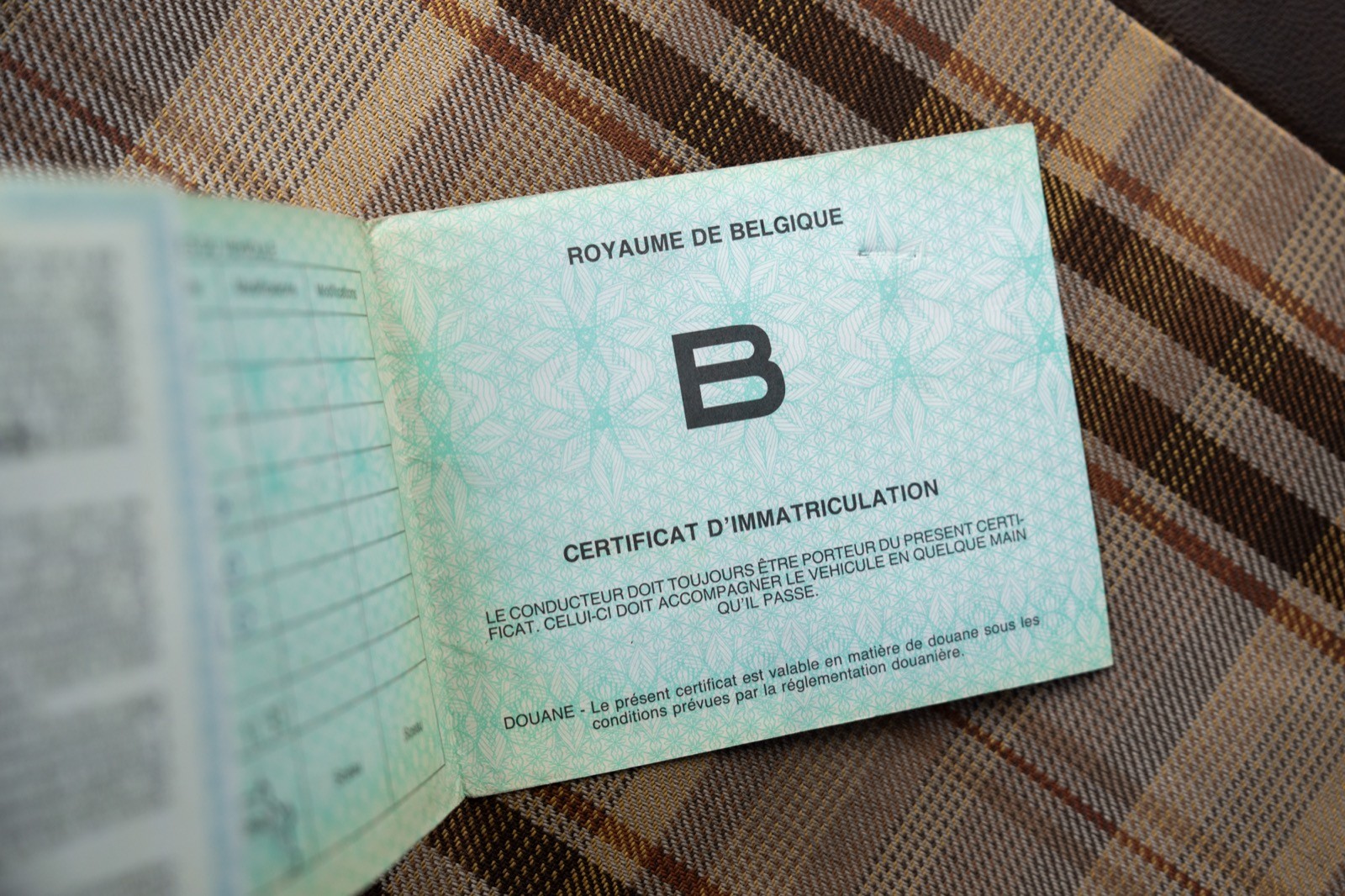 Open passport lying on a textured surface, showing identification page and personal details.