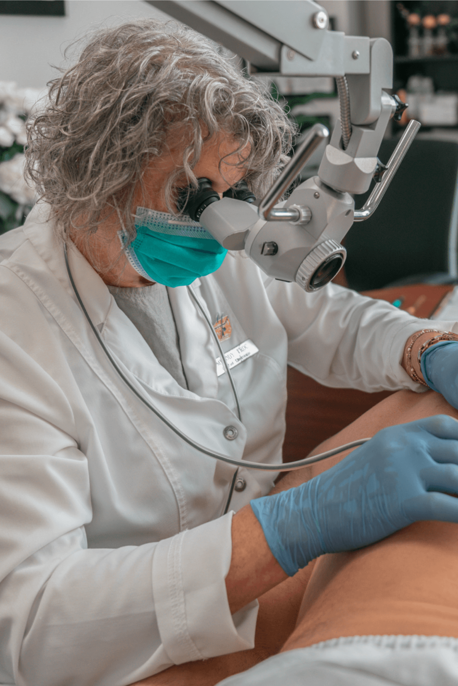 Melody Allard working under a magnifying lamp during an electrolysis treatment