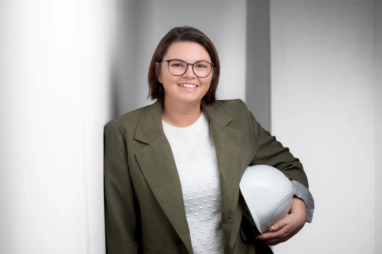 Portrait von Melanie Hohaus-Janssen mit Baustellenhelm in der Hand