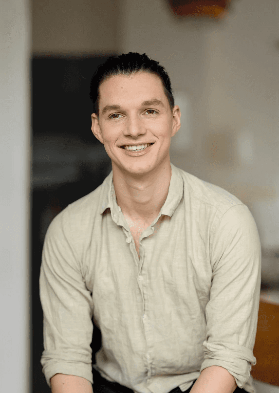 Smiling person seated indoors — founder of Seven Life Areas, offering guidance for living with clarity, harmony, and purpose.