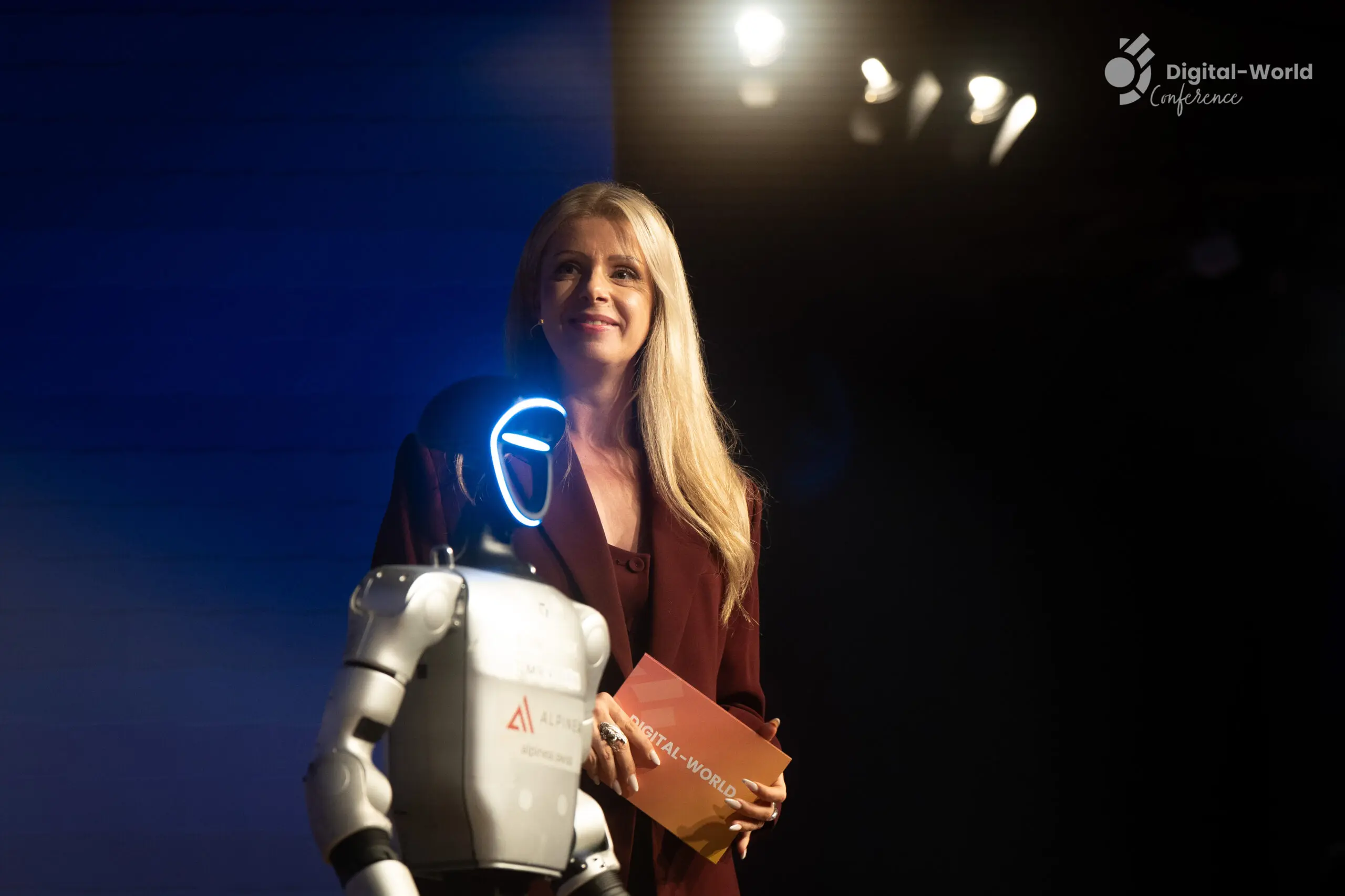 Moderatorin Désirée Lehmann bei der Eventmoderation zusammen auf der Bühne mit einem Roboter.