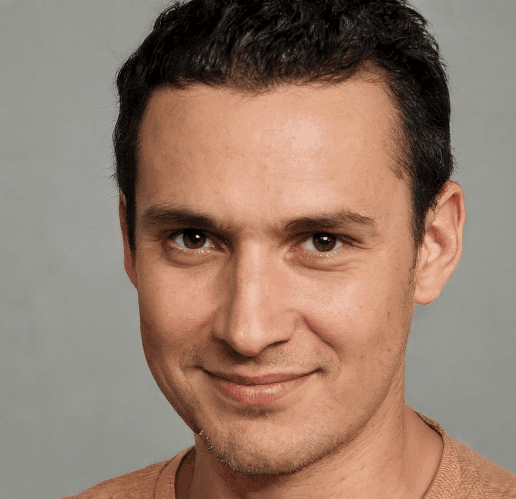 a man with a goatee smiles at the camera