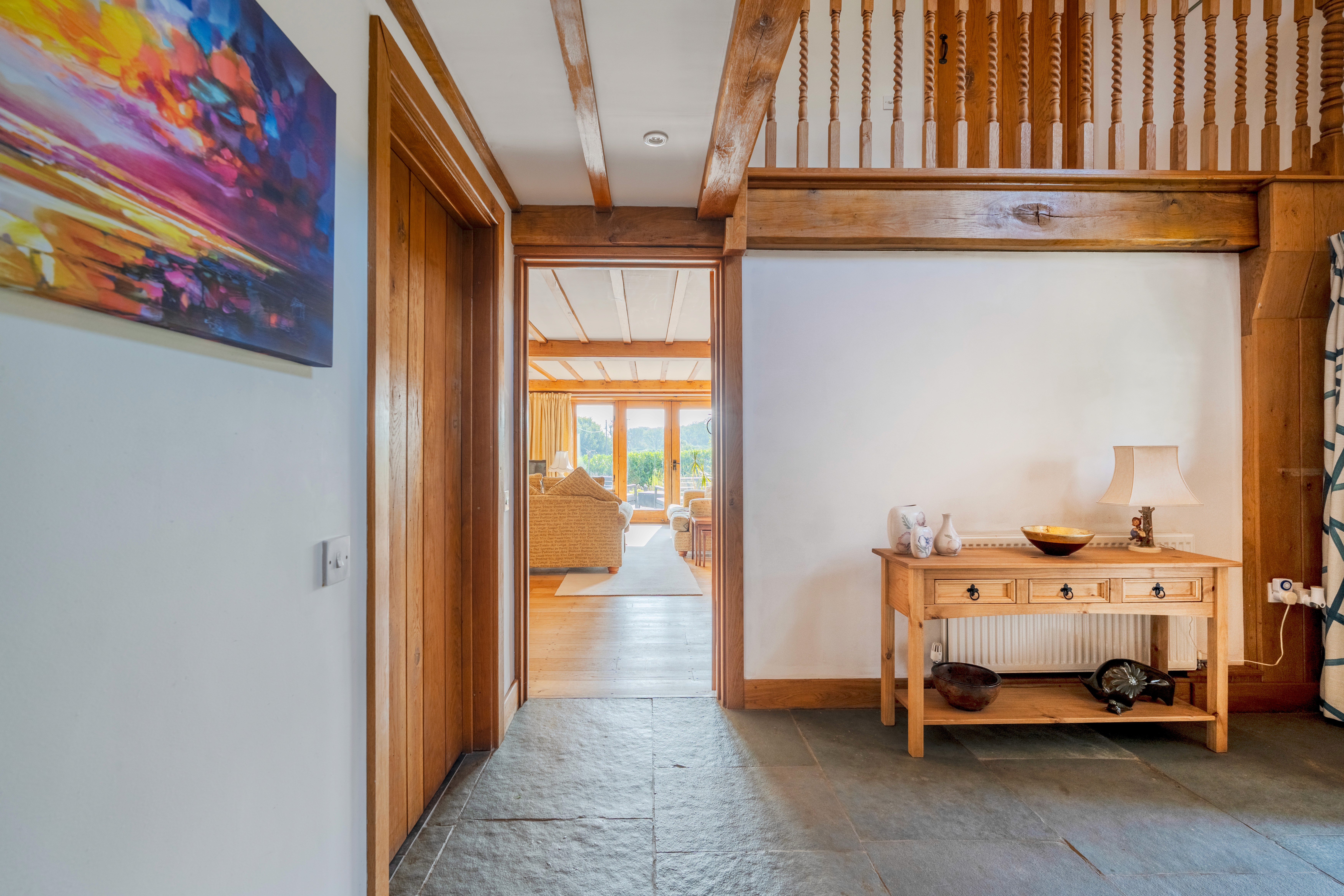 Bright cottage living room with exposed beams and large windows to the garden