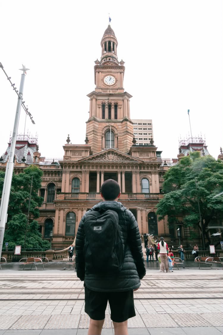 Person facing a historic city clock tower