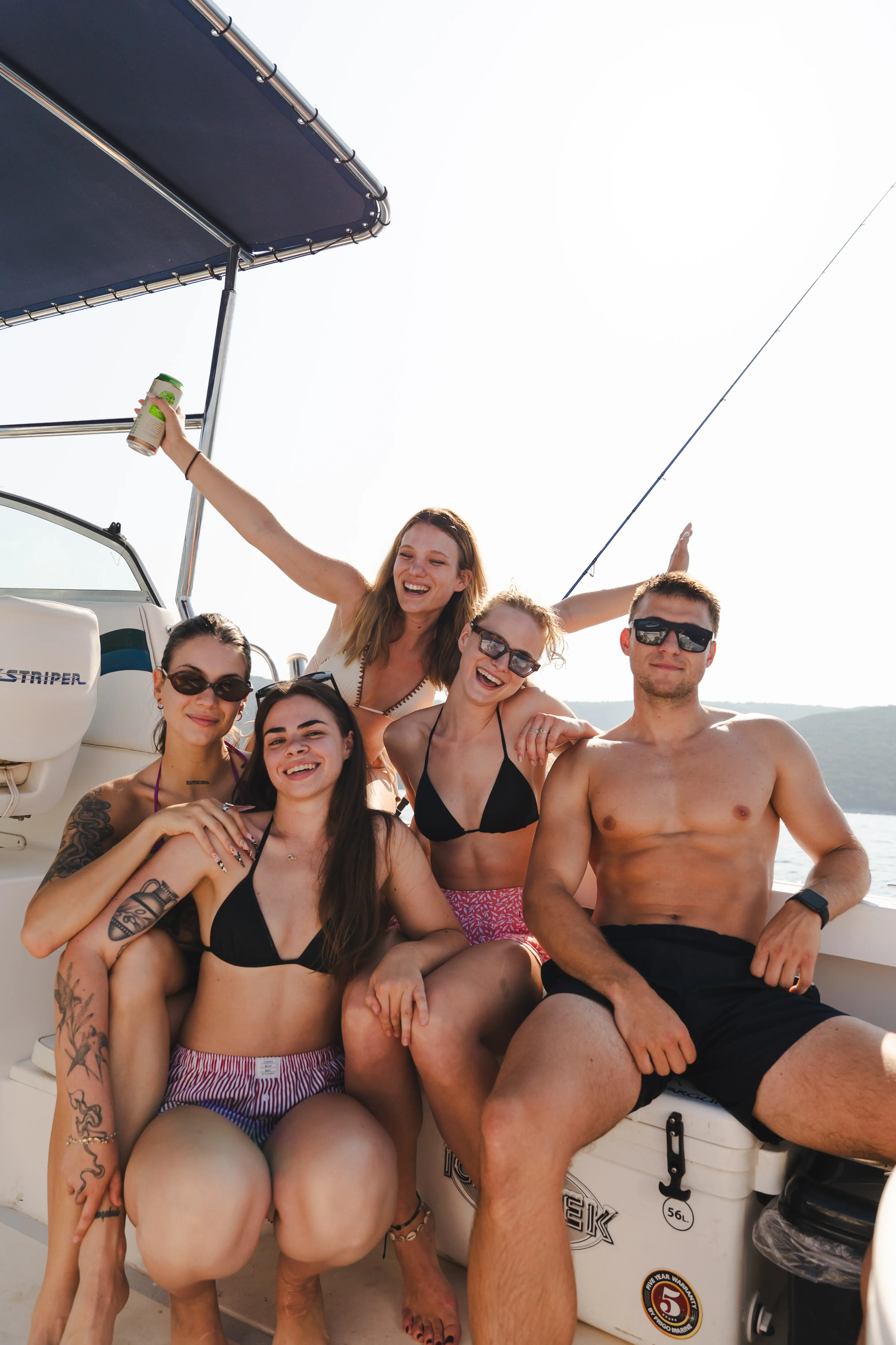 Group of young friends having fun during a boat trip on the Adriatic Sea, enjoying a sunny day on a speedboat.
