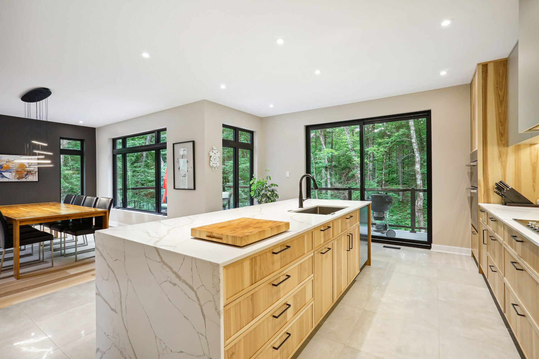 Îlot de cuisine orienté vers les fenêtres et la terrasse.