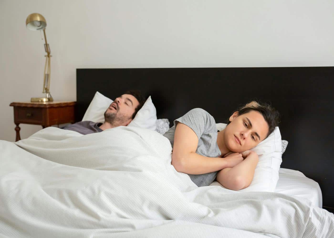What is sleep apnea - man snoring and woman lying awake
