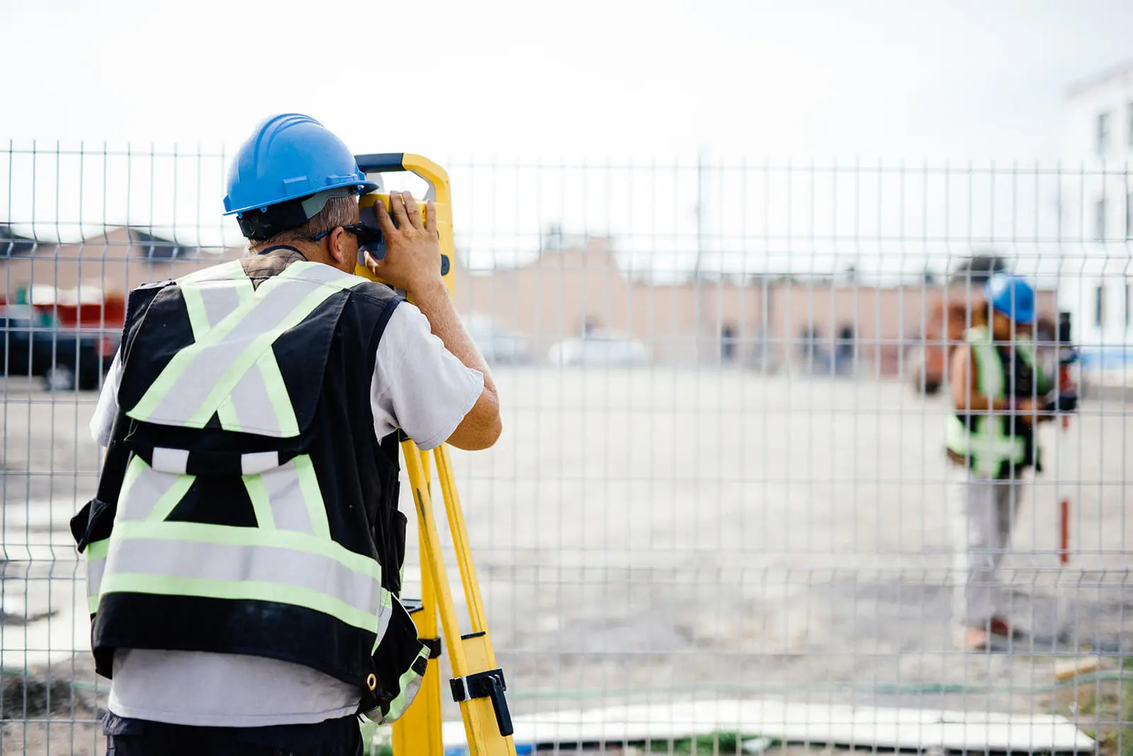 Land surveyor using surveying equipment at a construction site