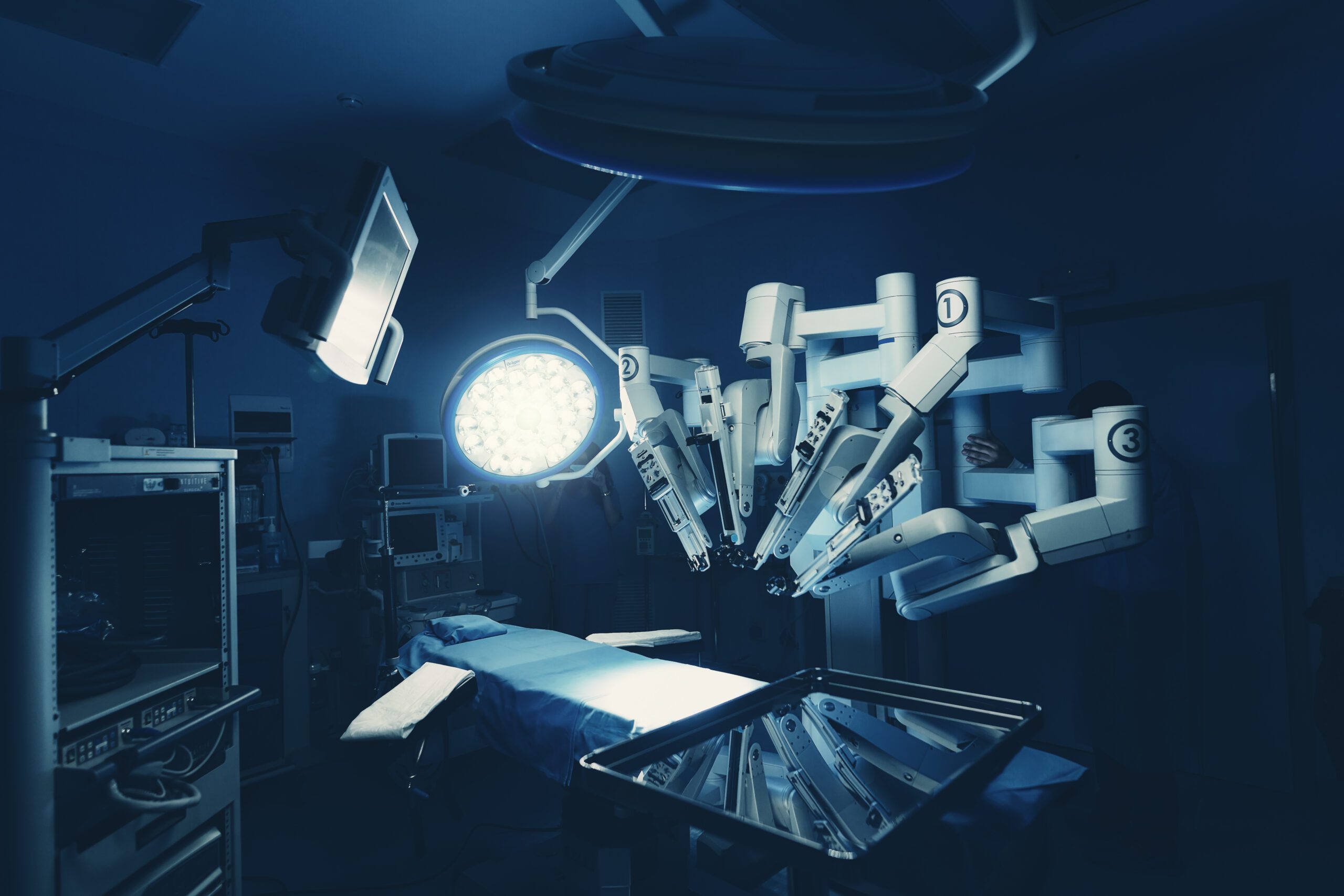 An operating room with a light on and a robotic instrument
