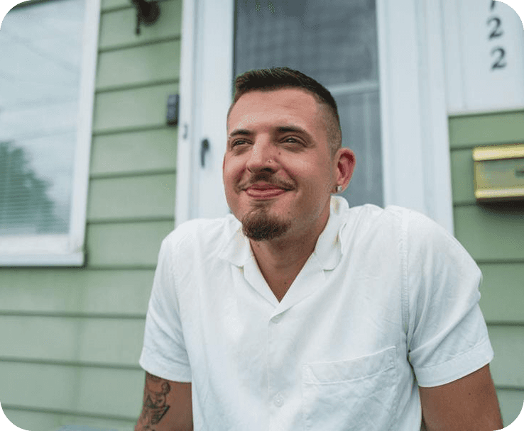 A man sits on front porch smiling