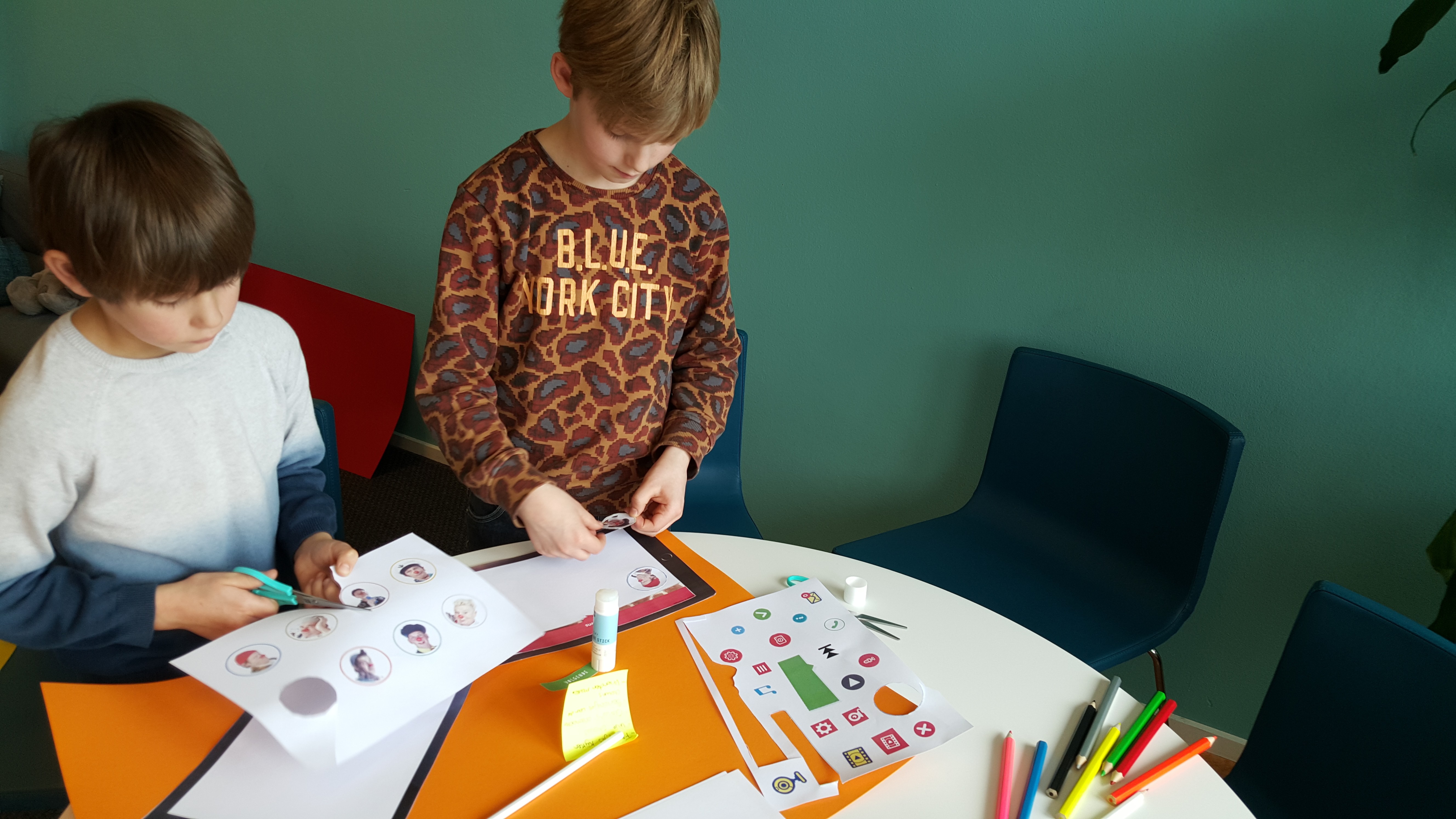 Kinderen knutselen samen aan een tafel hoe de CliniClowns app eruit kan komen te zien.