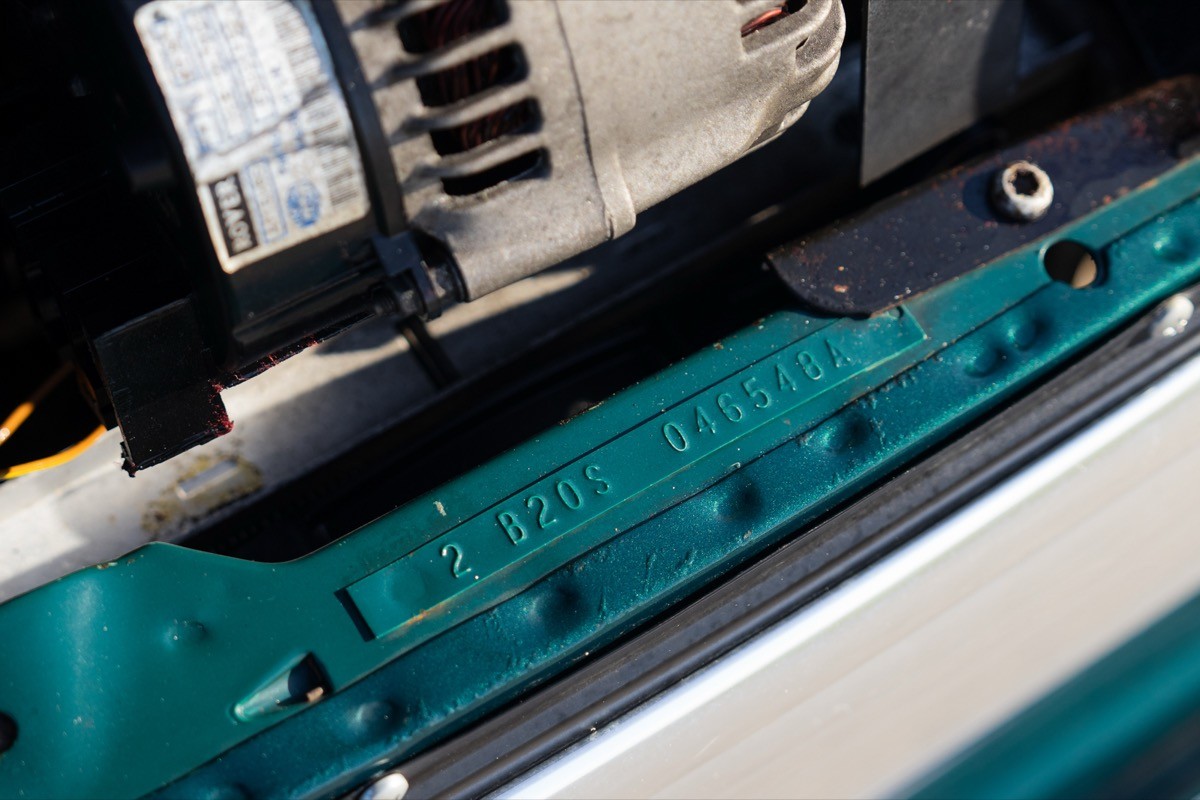 Close-up of a machine's interior components, featuring a teal casing and metallic parts.