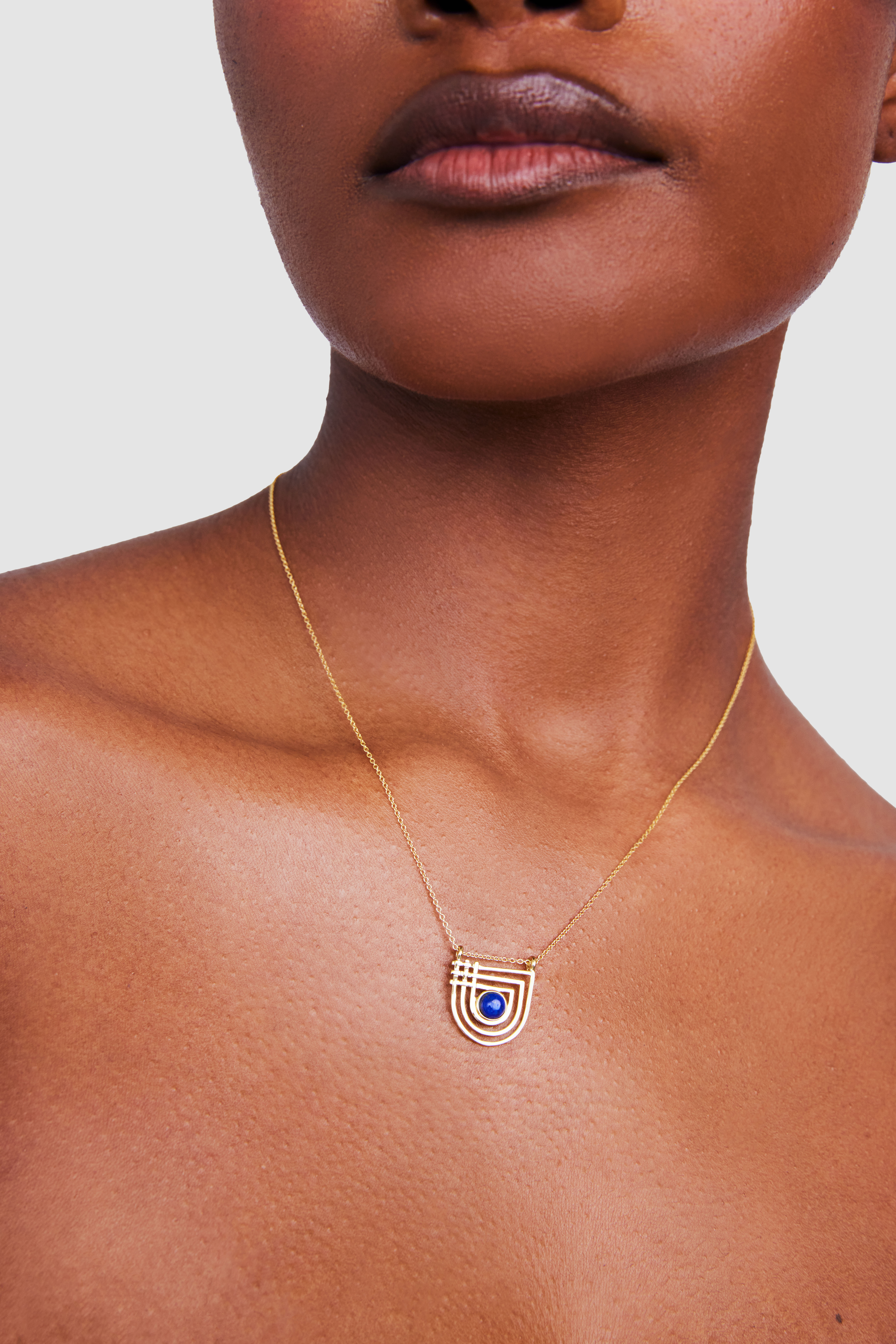 Young woman with dark hair and bangs, wearing red.