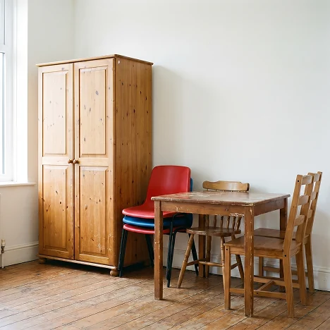 Fotografía de muebles de madera en buen estado, mostrando un ropero, una mesa de comedor con sus sillas y un sillón para sala.