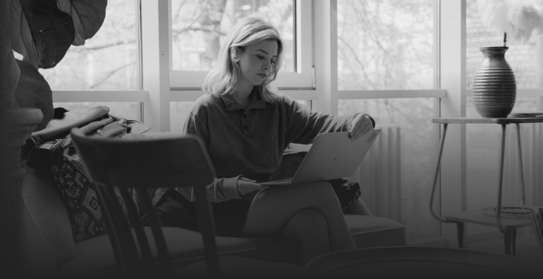 Woman sitting on a couch and working with a laptop