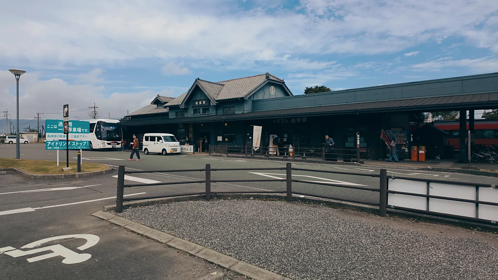Coaches and vans at a timber-framed roadside station near Kurokawa Onsen
