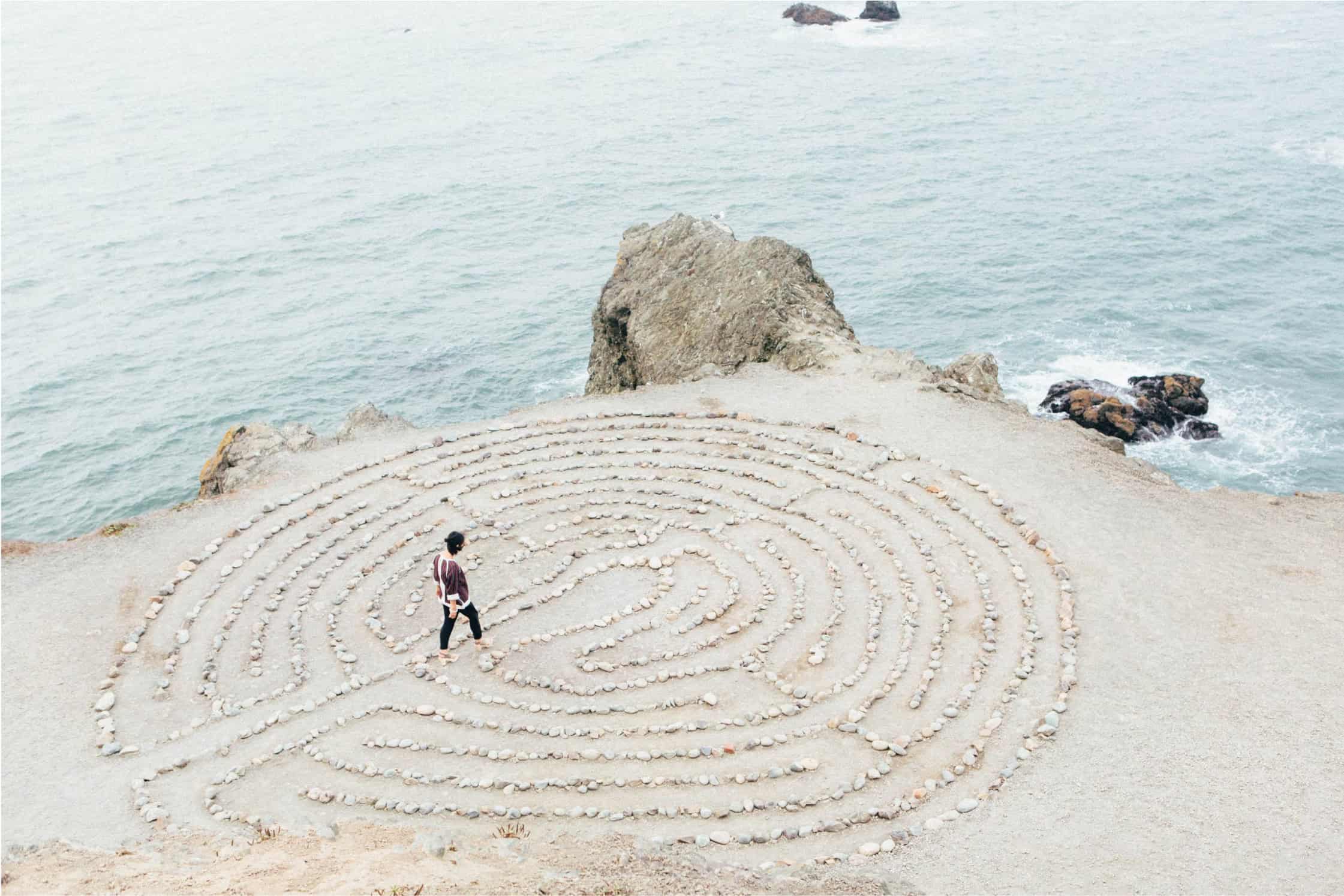 Thread or maze drawed on the sand with a woman walking in it