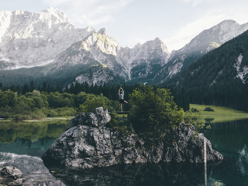 red train travelling near body of water