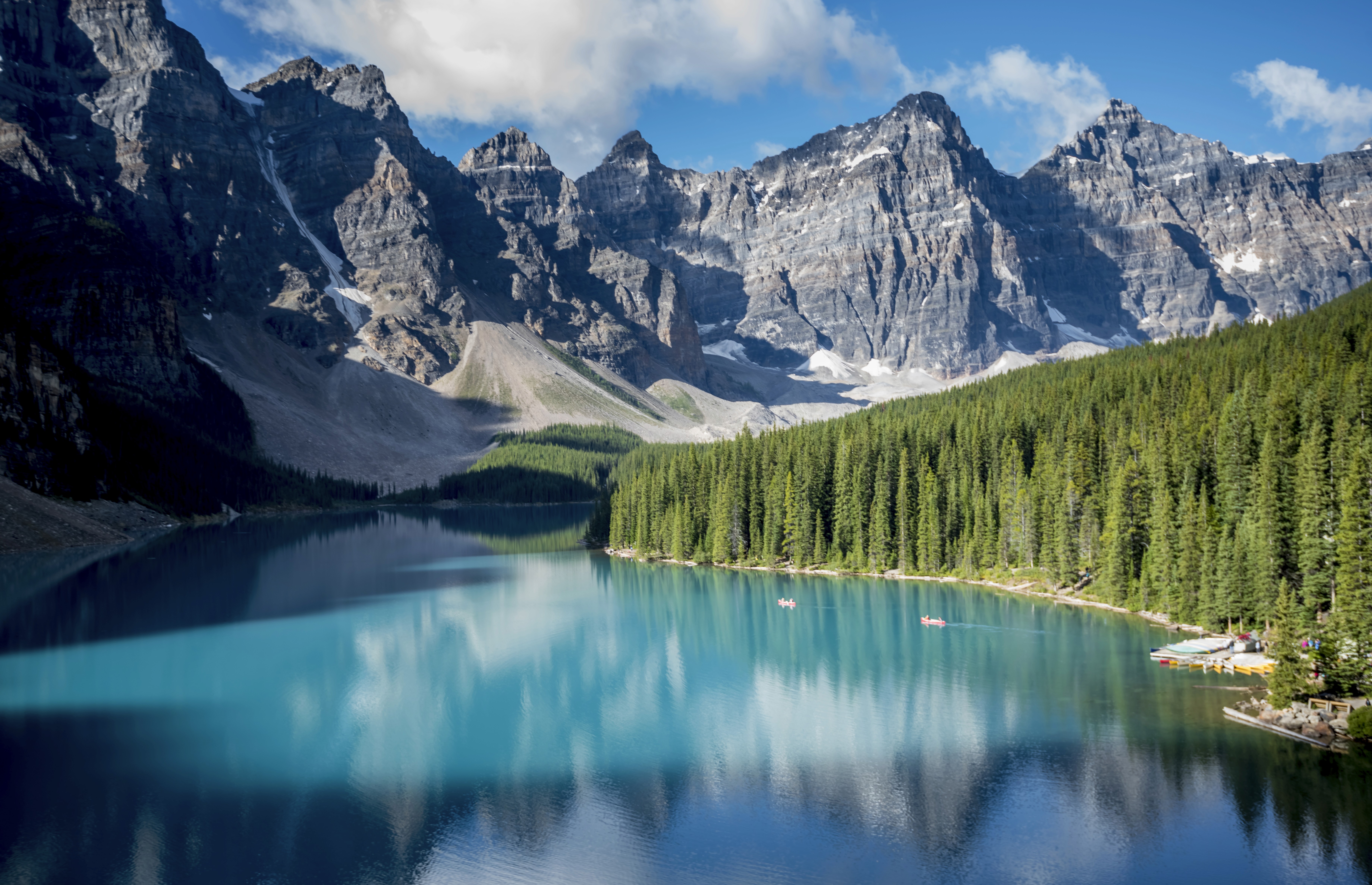 woman in blue tank top standing beside white wall