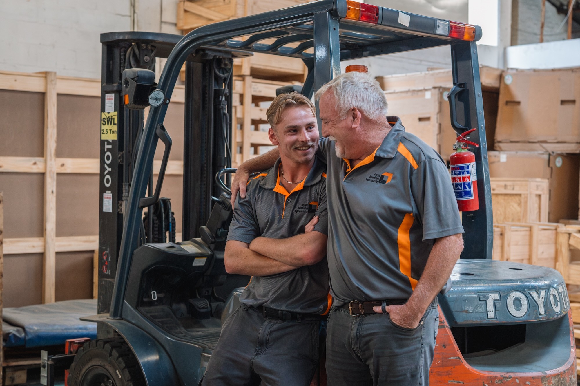 Managing Director Owen Bottomley and Liam Bottomley sharing a moment in the warehouse, representing the company's family leadership and legacy.