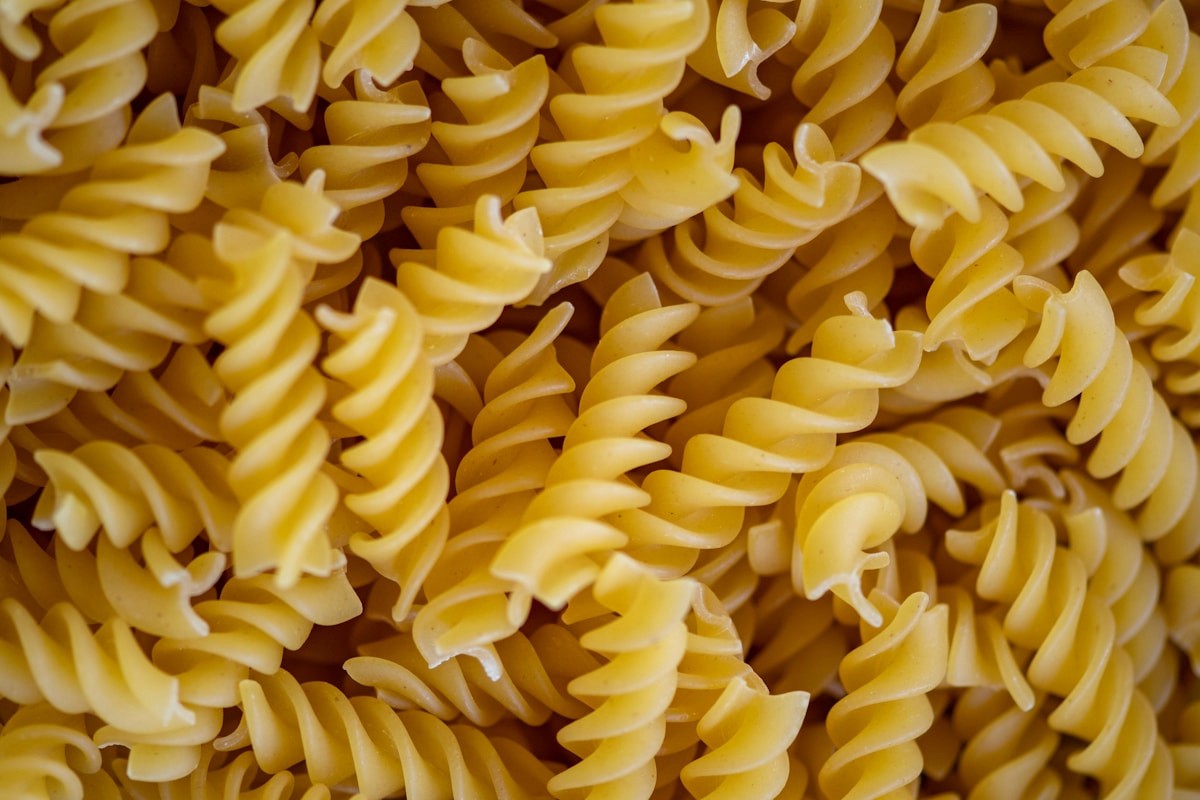 A close-up of dried whole-grain pasta, a carbohydrate-rich fuel source for athletes.