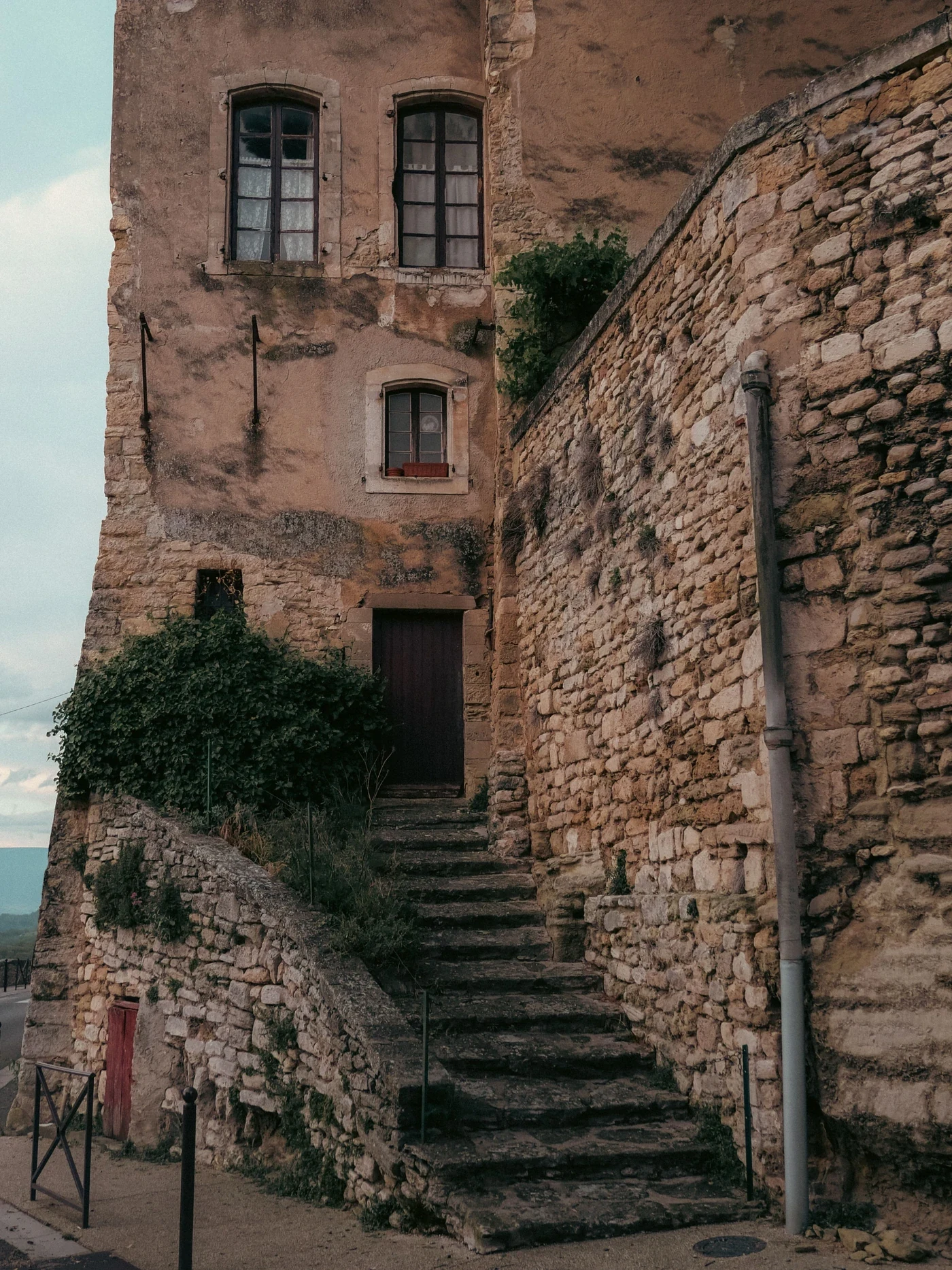 Old stone stairway climbing between weathered houses in a French village
