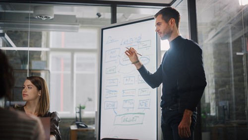 Researcher gives presentation to study team in meeting room