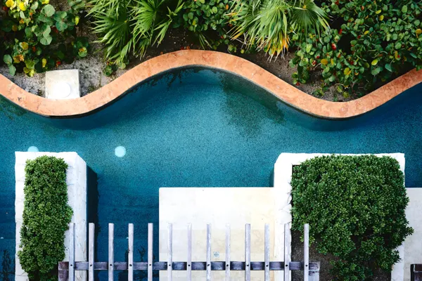 Vista aérea da piscina serpenteante de um spa rodeada de vegetação — transferes para hotéis, termas e spas · Táxi Afonso · 11 Moledo e Cristelo