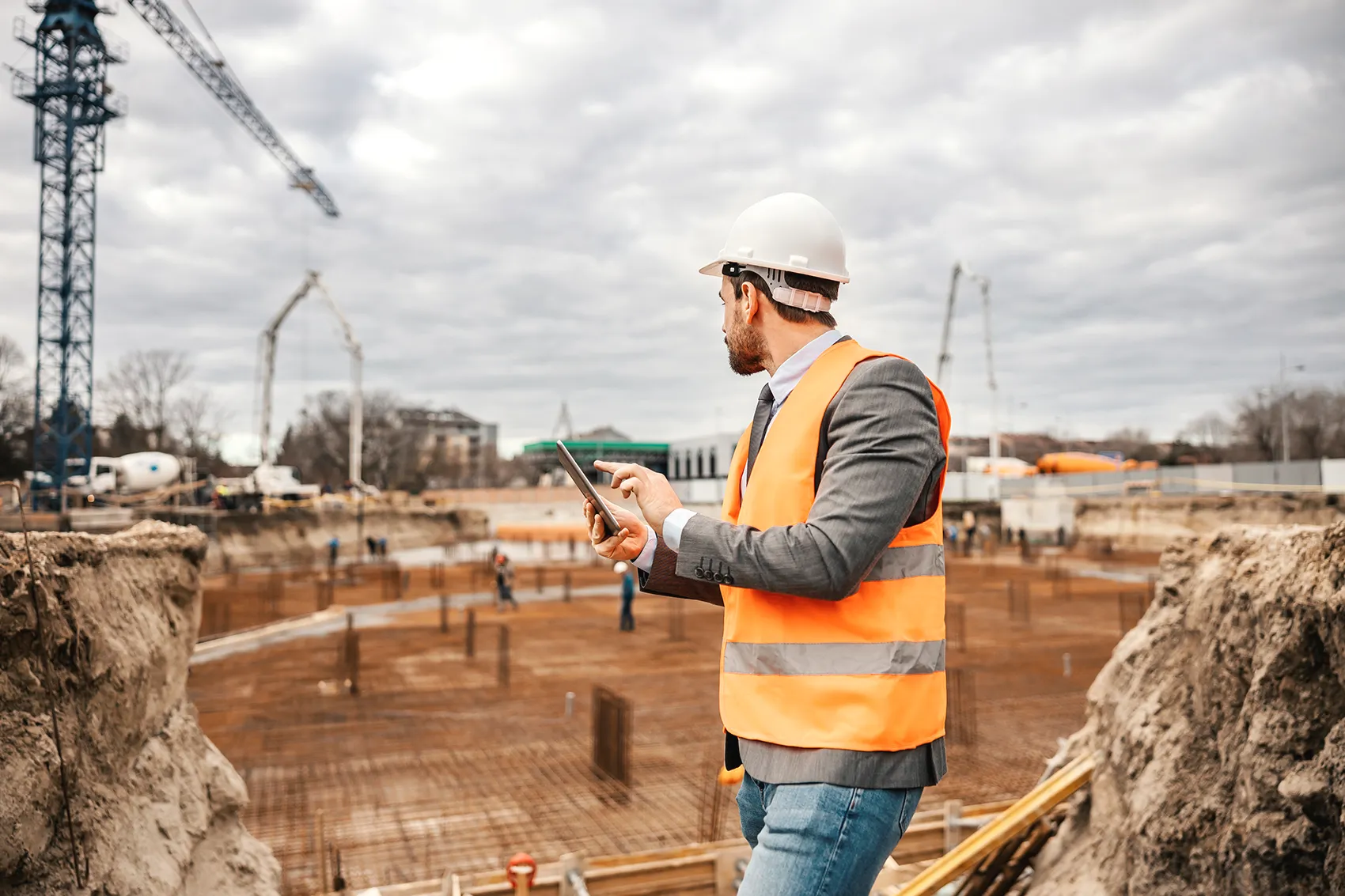 Bauleiter dokumentiert den Stand einer Baustelle mit seinem Tablet