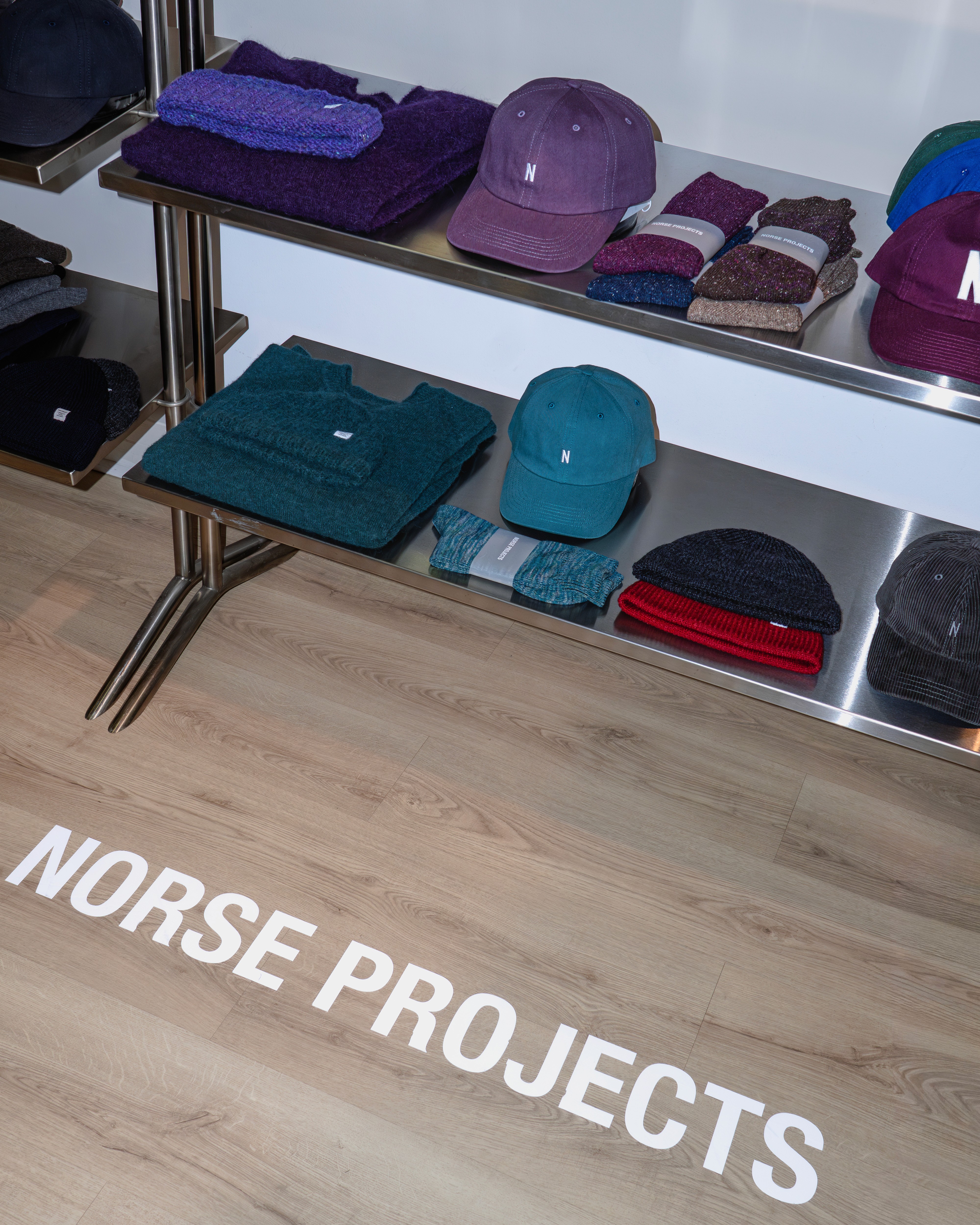 Les accessoires Norse Projects comme des casquettes et des écharpes posés dans le showroom Clothette