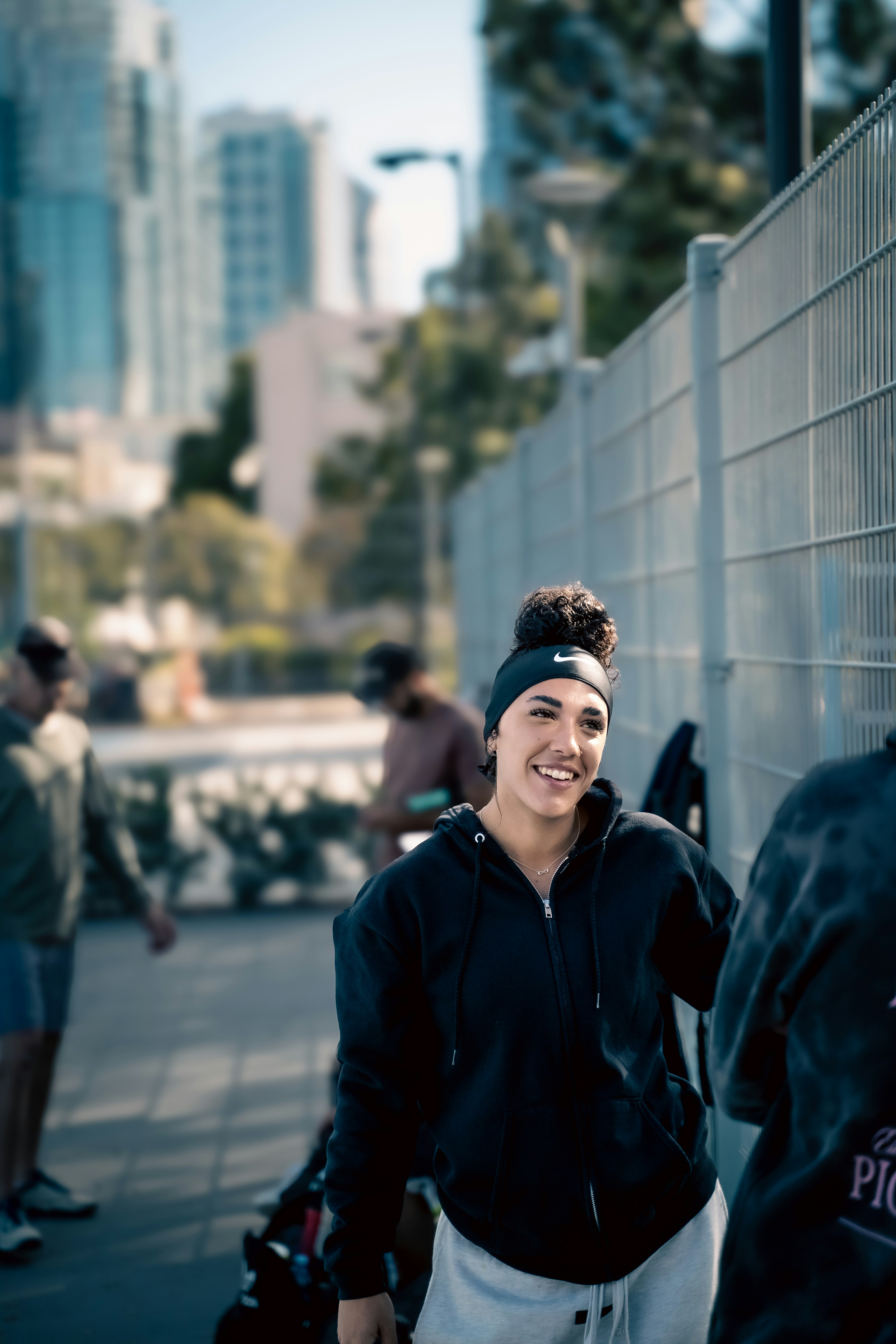 A woman standing next to a wall with a tennis racket in her hand