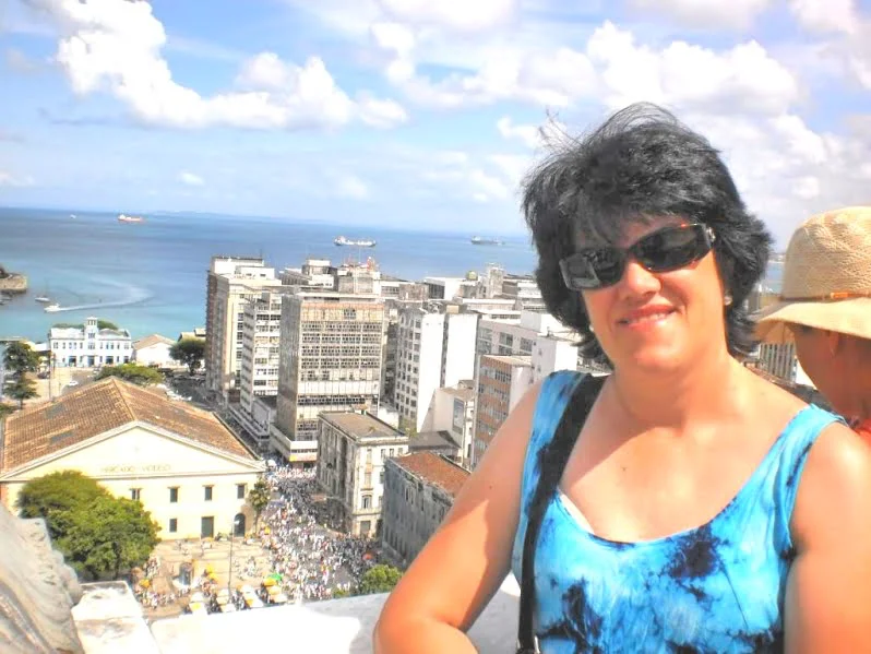 Mulher apreciando vista panorâmica de cidade litorânea durante viagem