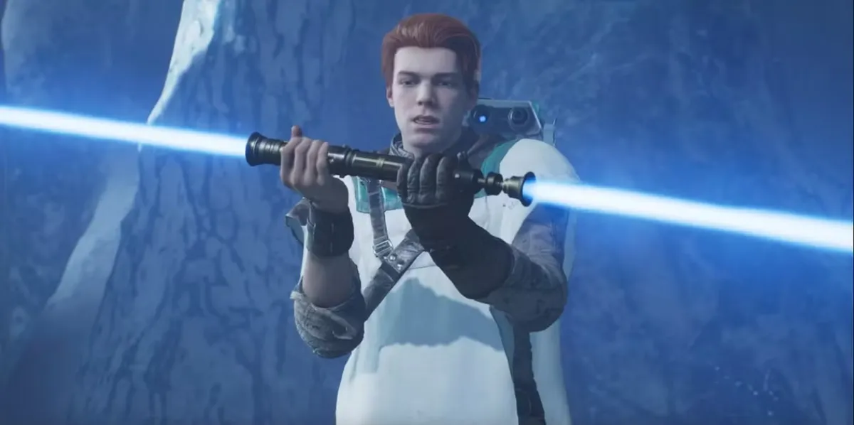 Cal Kestis holding his double bladed blue lightsaber. Cal is wearing a white poncho over his classic outfit from Jedi: Fallen Order with BD-1 on his shoulder