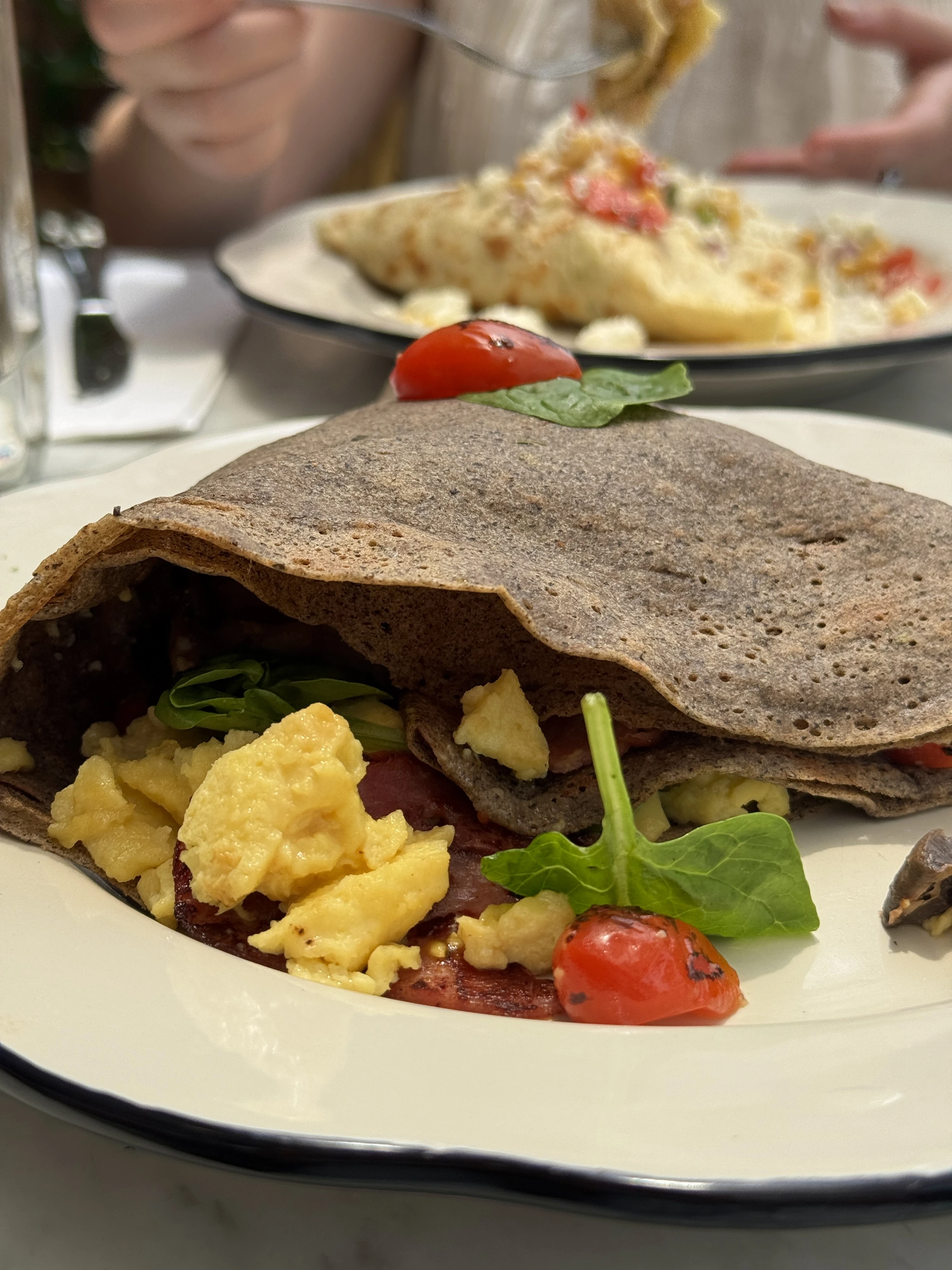 a table on the open-air patio before enjoying a delicious gluten-free buckwheat crepe made with freshly roasted vegetables and turkey bacon.