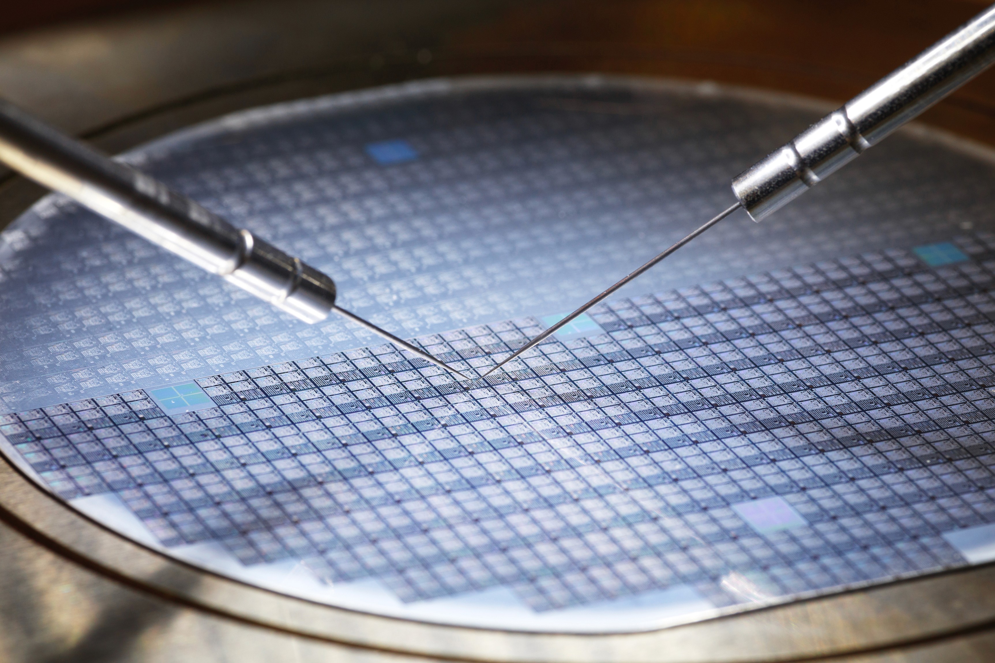 Close-up of a semiconductor wafer being tested with precision probe needles.