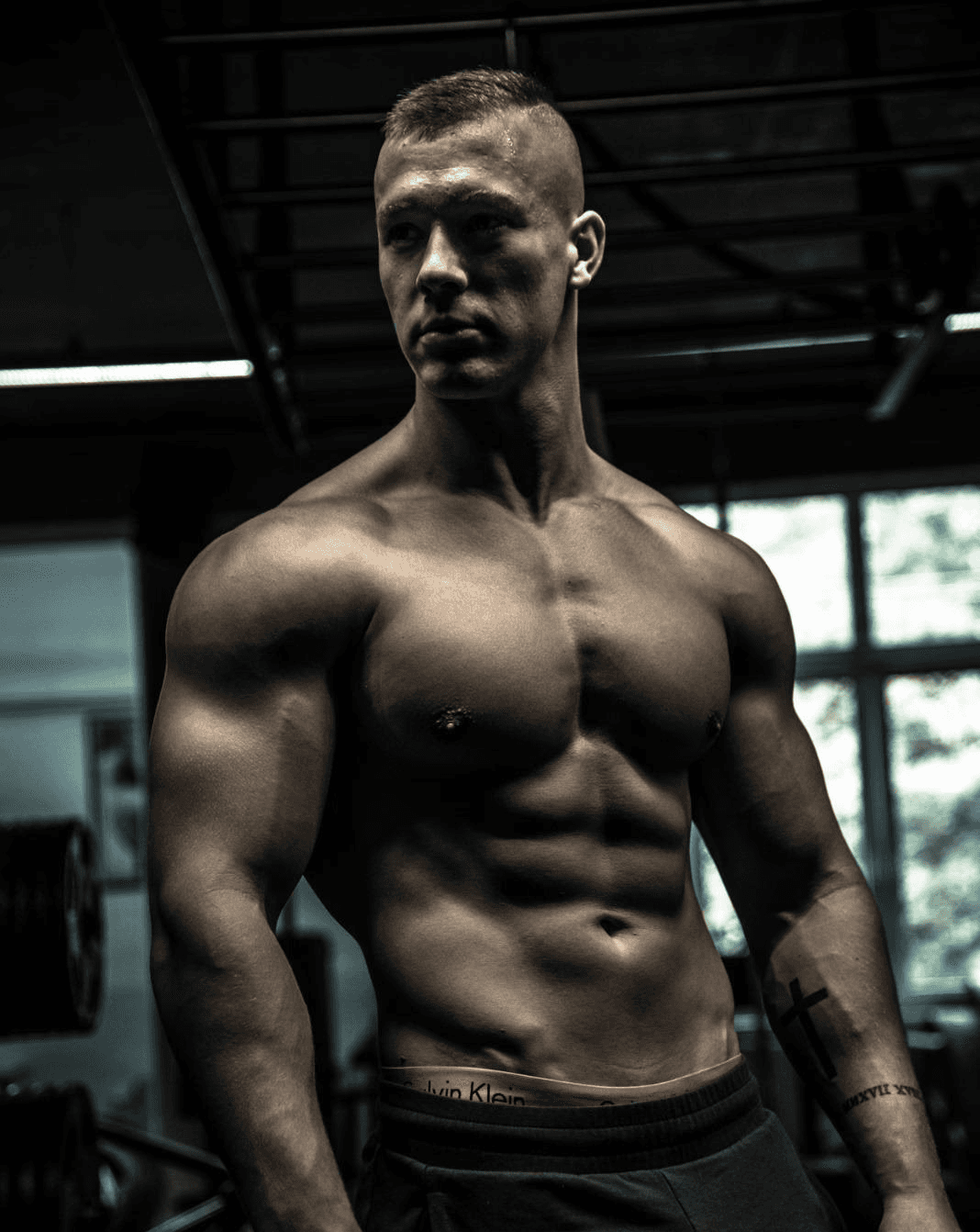 Two individuals are working out in a gym, focusing on dumbbells and strength training equipment.