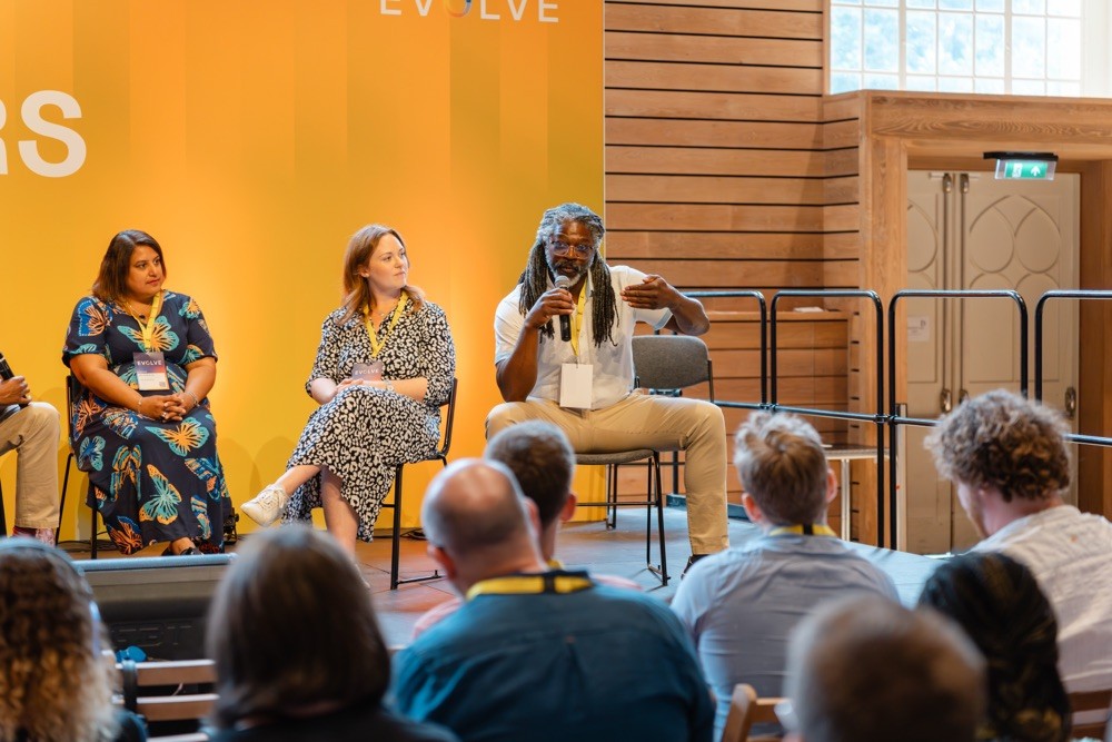 Panel discussion at Evolve 26 tech conference in Brighton with speakers addressing a seated audience