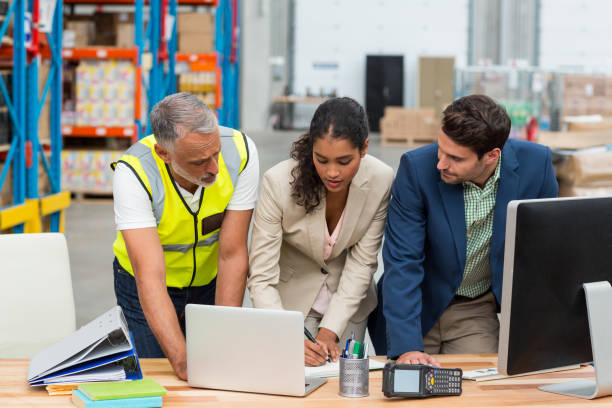 image of three people all looking at a screen and making notes
