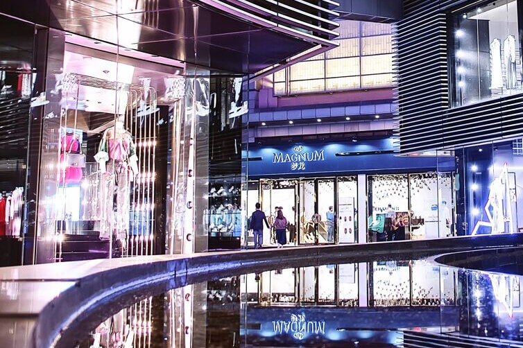 Modern shopping center with fashion stores at night
