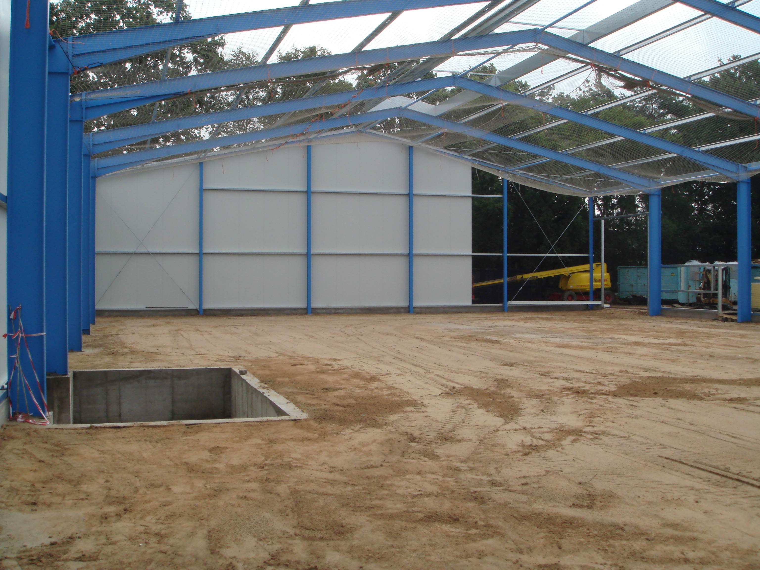 Blau gestrichene Stahlkonstruktion einer Industriehalle, Rohbau mit Dach und Seitenwänden, Innenraum.